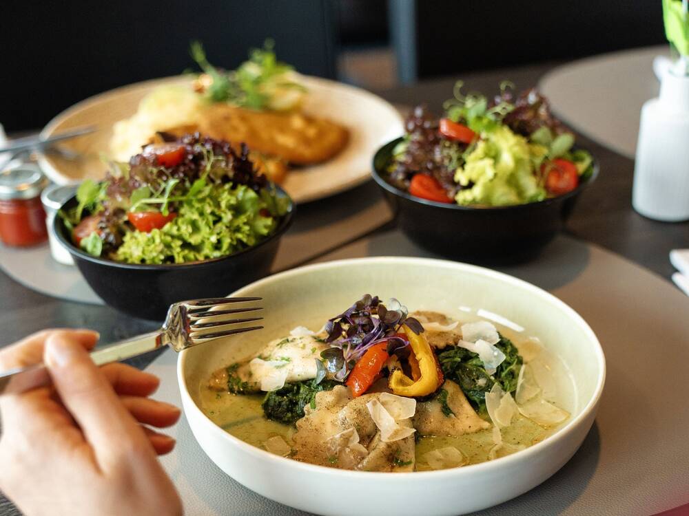Leckeres Essen wie Salate und Allgäuer Spezialitäten serviert im PanoramaRestaurant des AllgäuSternHotels.