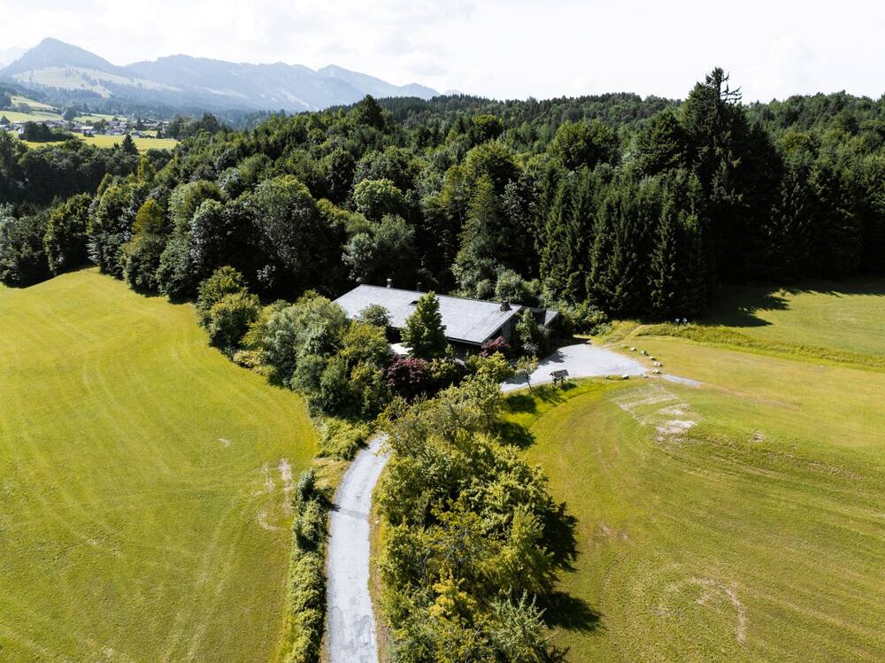 Sonnenkopfhütte des AllgäuSternHotels aus der Vogelperspektive mit Bergen und Almwiese.